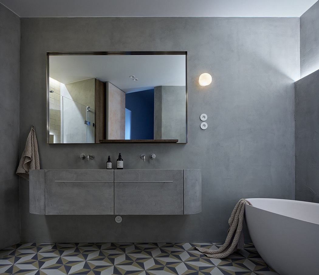 Minimalist bathroom with concrete walls, floating vanity, and geometric tile flooring.