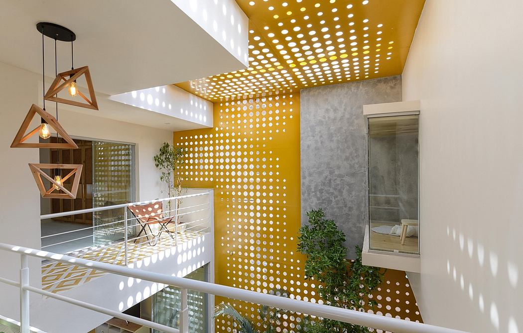 A modern interior with eye-catching yellow-dotted walls, geometric lighting, and a glass railing.