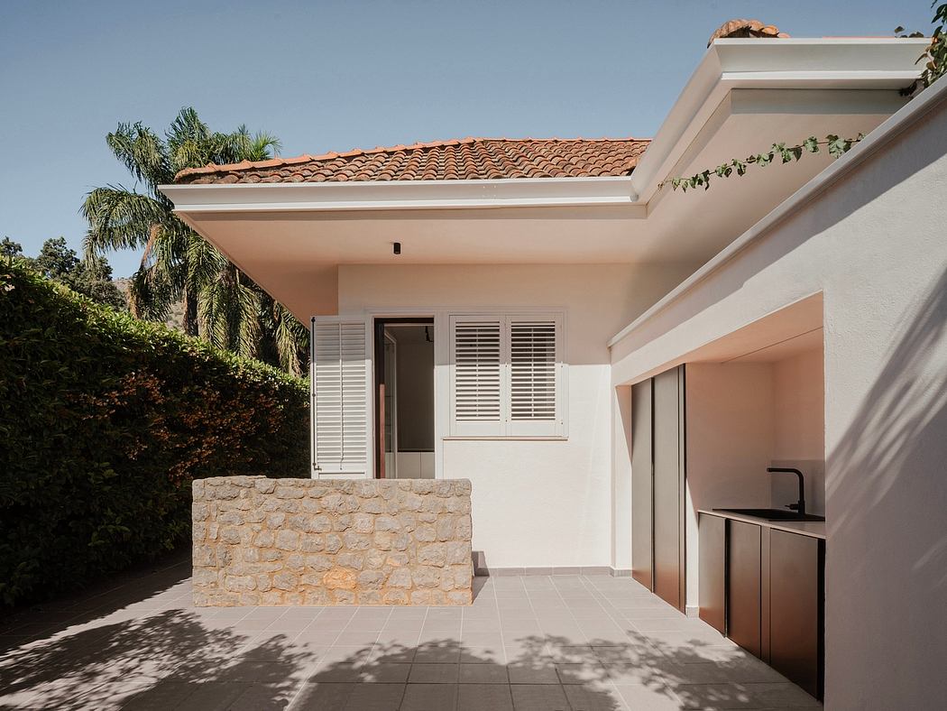 Modern Mediterranean-style residence with tiled roof, stone accents, and outdoor kitchen.