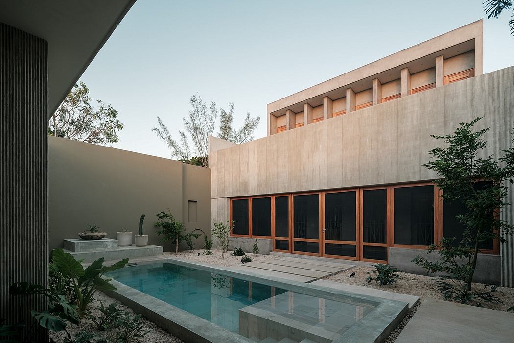 Minimalist modern architecture with concrete facade, large windows, and swimming pool.