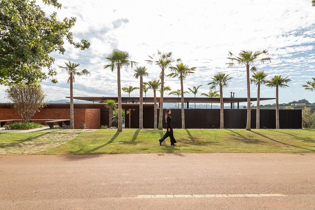 A modern building surrounded by tall palm trees on a well-landscaped grassy area.