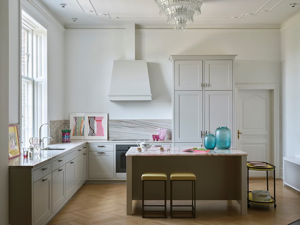 Elegant kitchen with white cabinets, marble countertops, and a crystal chandelier.