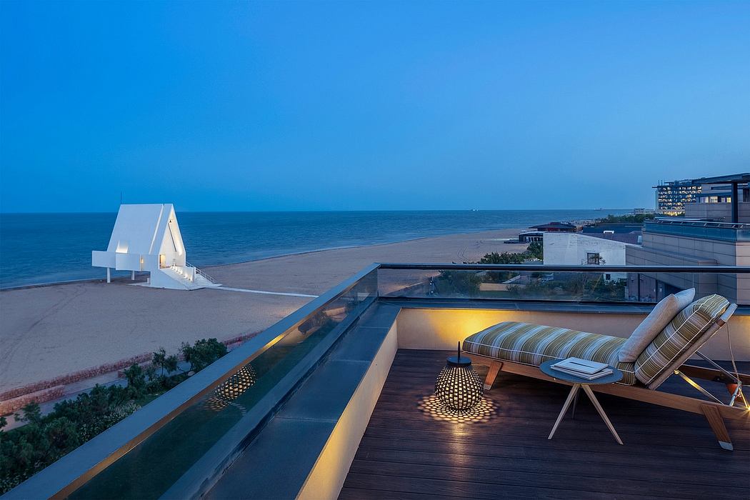Sleek, modern balcony overlooking the beach, with plush seating and ambient lighting.