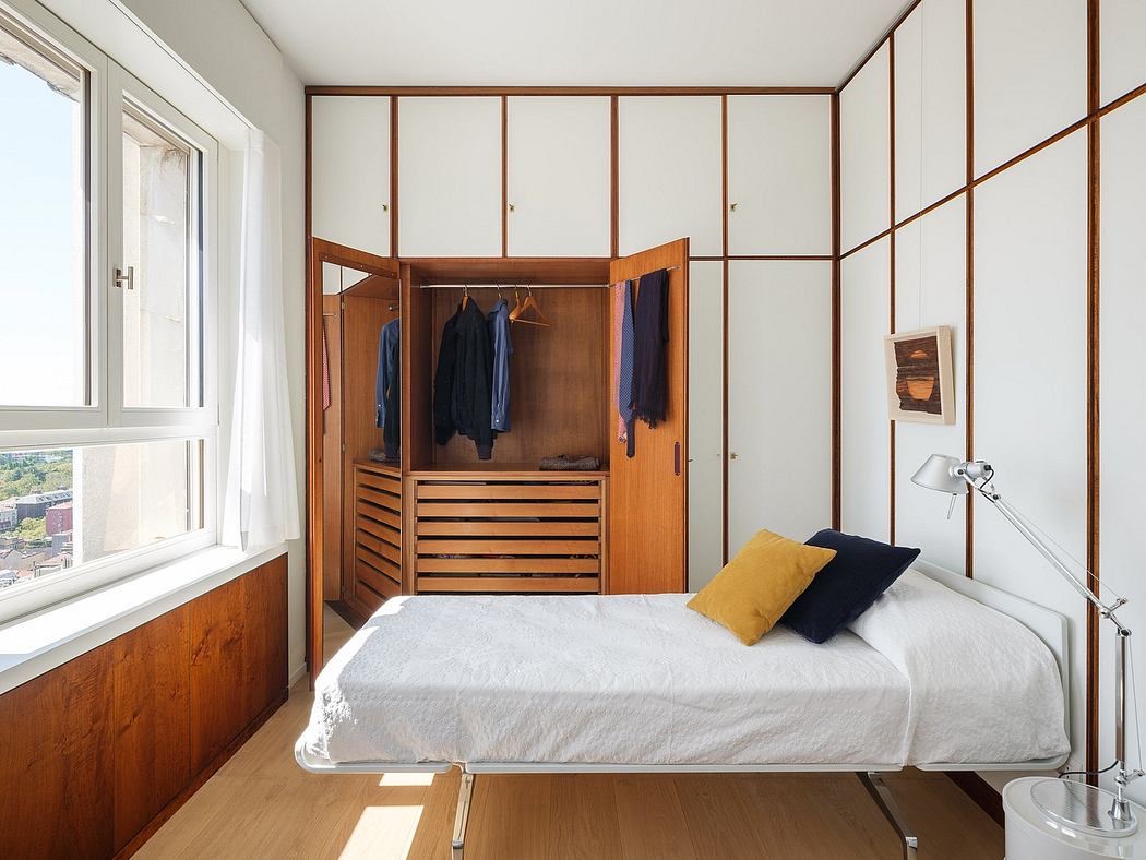 Minimalist bedroom with wood-paneled walls, built-in closet, and ample natural light.