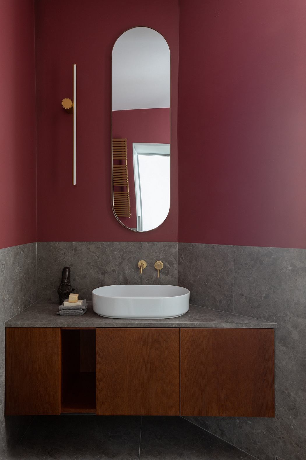 Minimalist bathroom design with a curved mirror, warm-toned wall, and floating vanity.