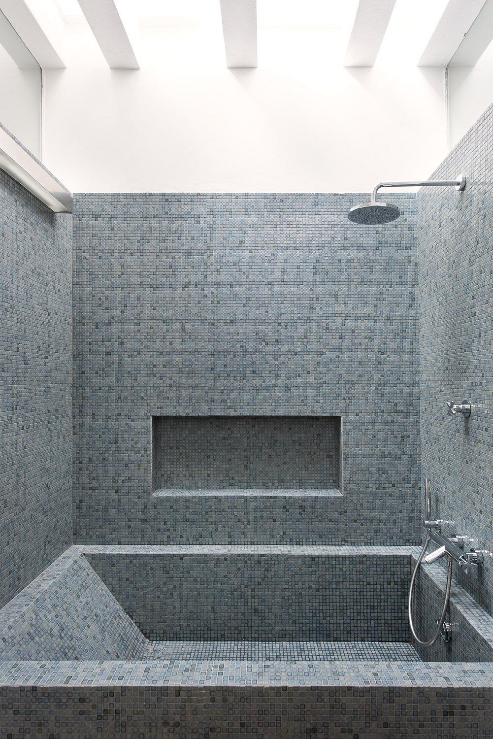 Sleek, modern shower room with gray mosaic tiling, built-in niche, and minimalist fixtures.