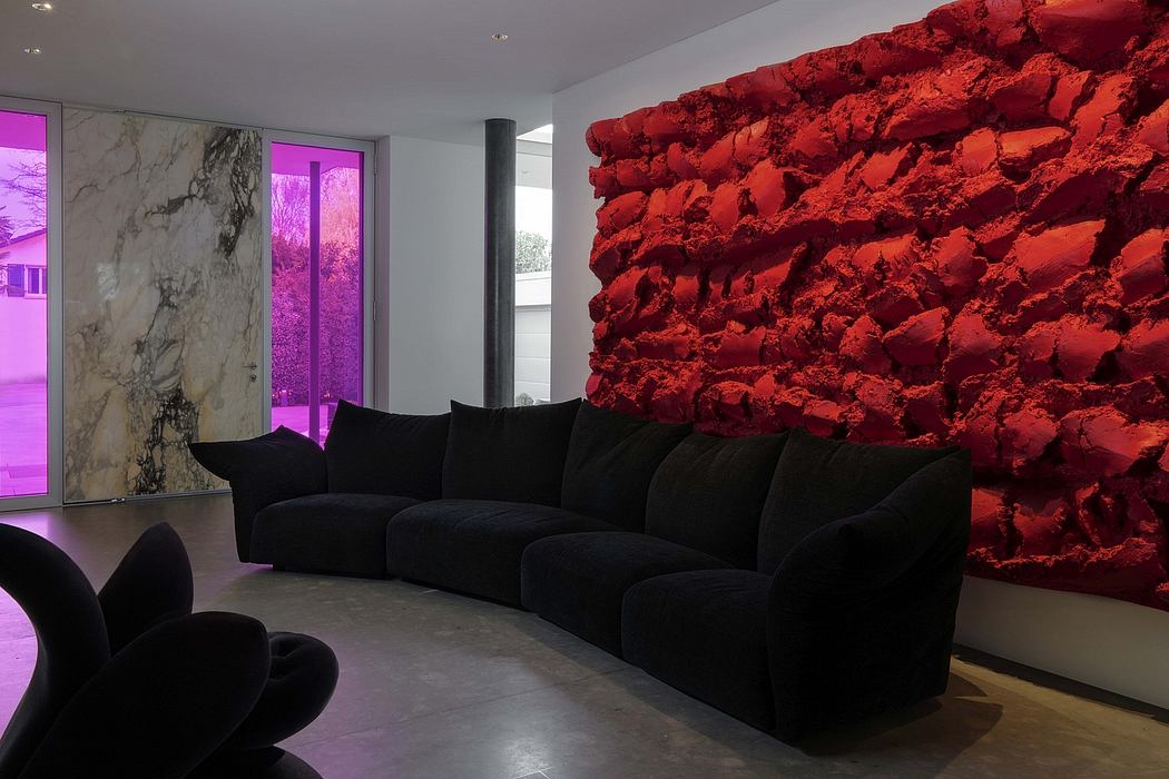 Striking combination of red rock wall, black furniture, and purple lighting creates a dramatic, modern interior.