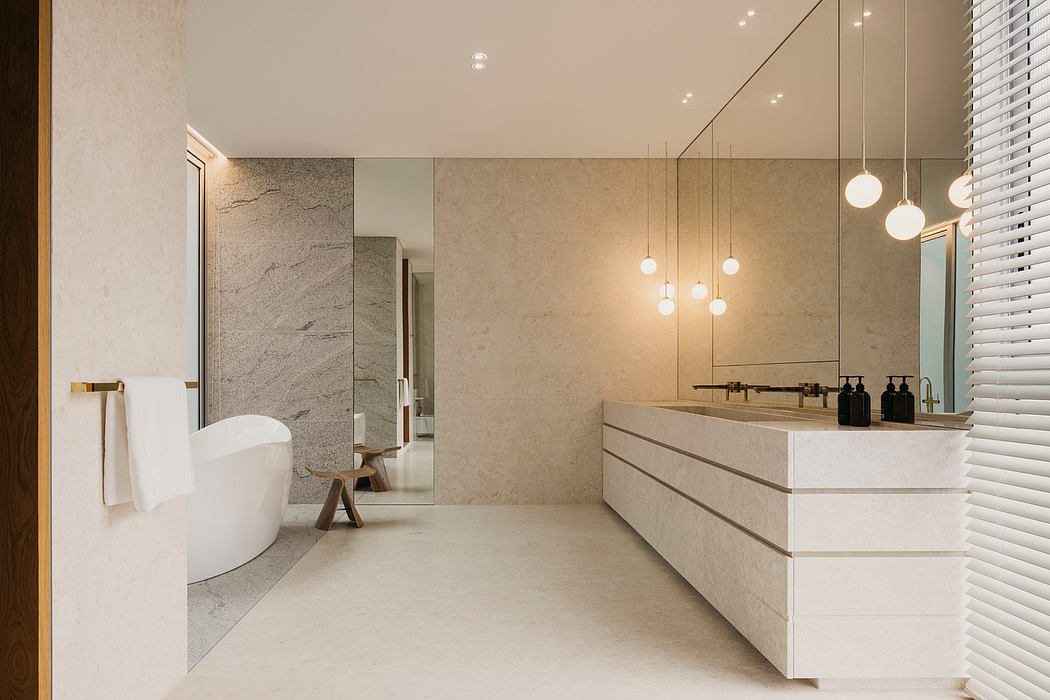 Luxurious bathroom with minimalist vanity, modern lighting, and marble walls.