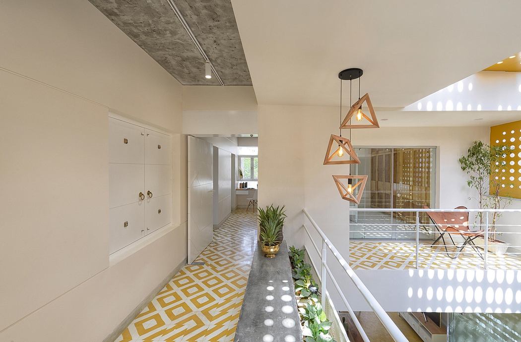 Sleek, modern entryway with geometric pendant lighting, tiled flooring, and potted plants.