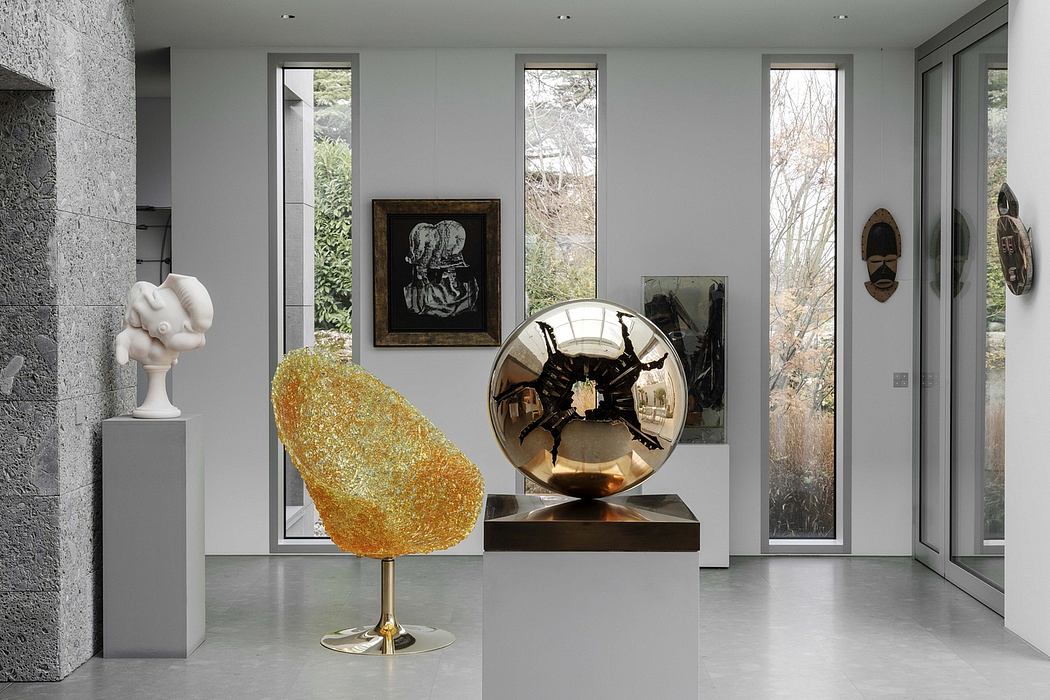 Minimalist interior design with large windows, abstract sculptures, and modern artwork.