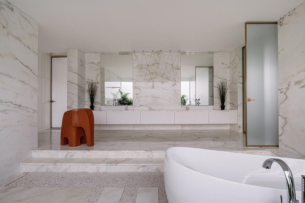 Spacious marble-clad bathroom featuring a sleek bathtub, vanity, and modern lighting fixtures.