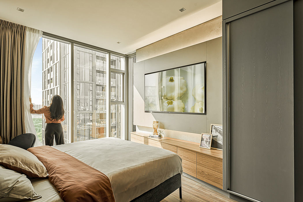 Spacious modern bedroom with large windows, minimalist furniture, and artwork.