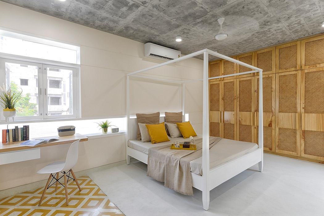 Spacious bedroom with concrete ceiling, wood paneling, and modern four-poster bed.
