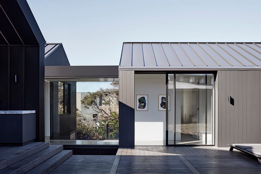 Sleek, modern exterior with clean lines, large glass panels, and a wooden deck.