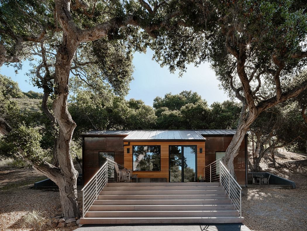 A modern cabin nestled among oak trees, with large windows and a wooden deck.