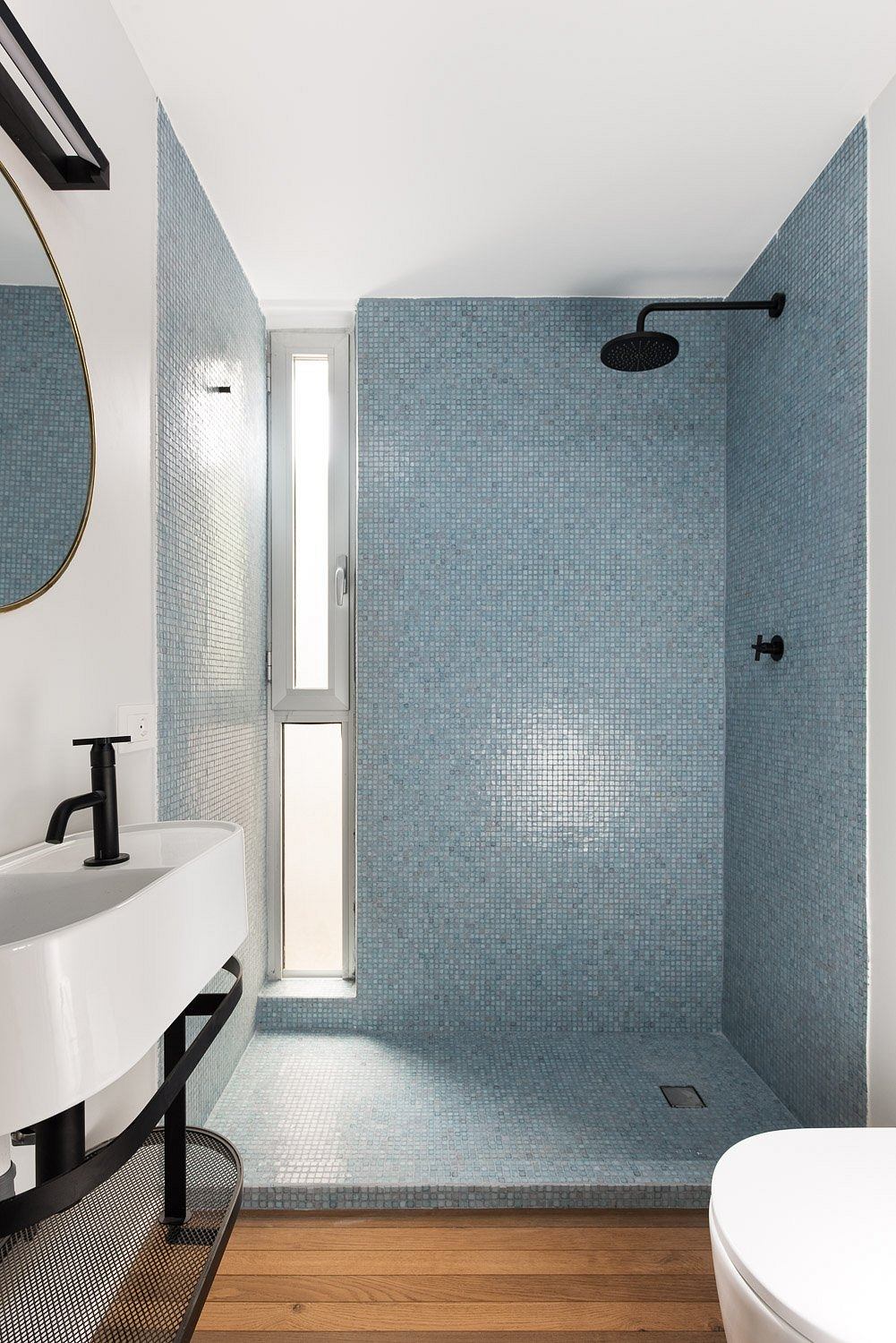 Sleek, modern bathroom with tiled walls, glass shower, and minimalist vanity.