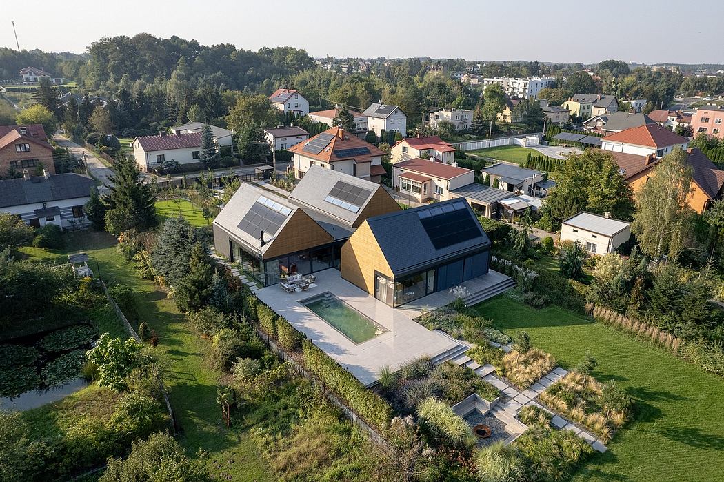 Modern, energy-efficient home surrounded by lush greenery and a serene pond.