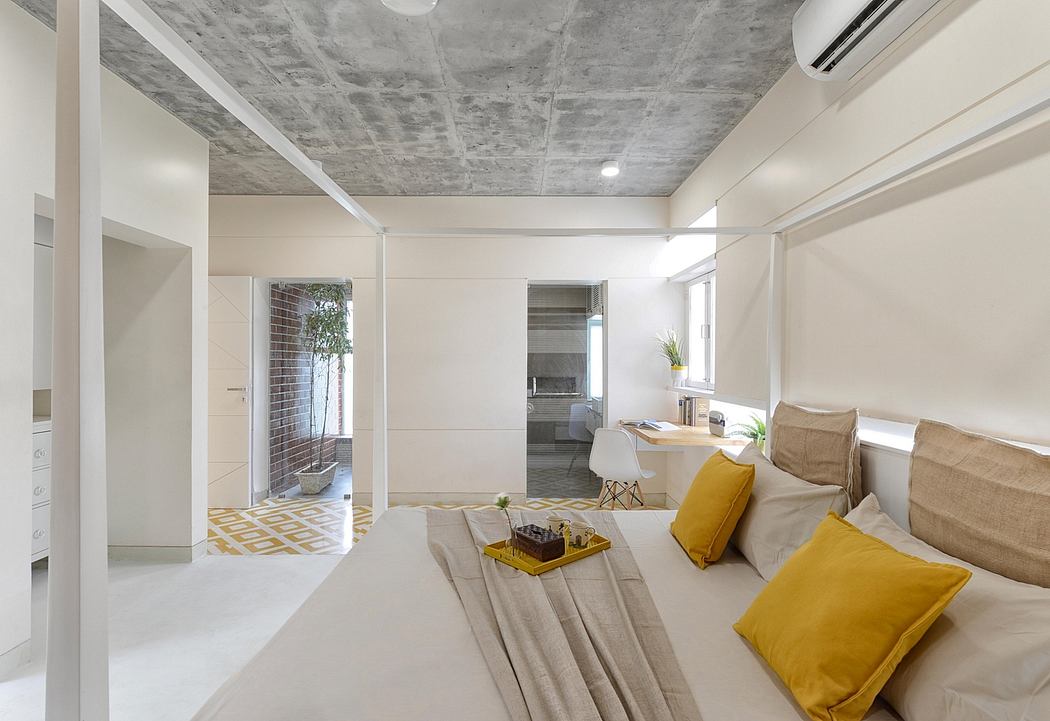 Modern open-plan interior with concrete ceiling, bright decor, and geometric tile flooring.