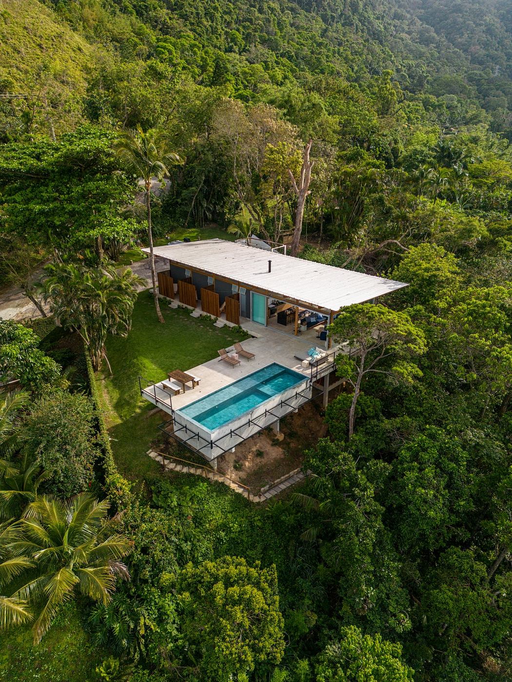 Stunning modern home nestled in verdant jungle canopy with infinity pool.
