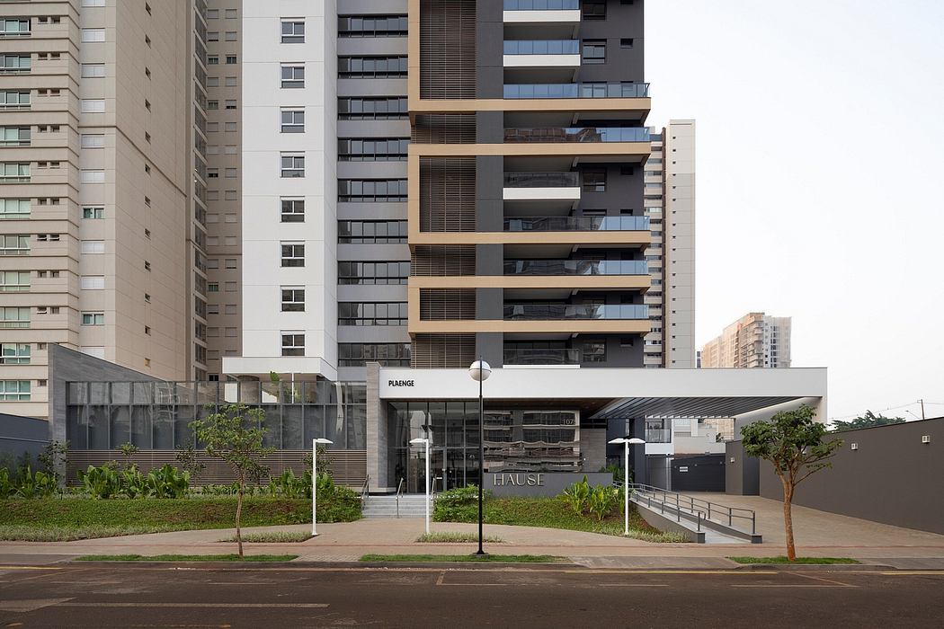 Modern high-rise apartment building with glass balconies, landscaped grounds, and pedestrian-friendly design.