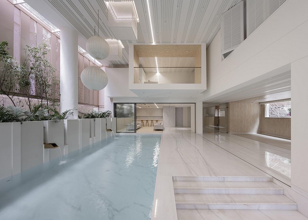 A modern and spacious interior with a sleek pool, hanging light fixtures, and minimalist decor.