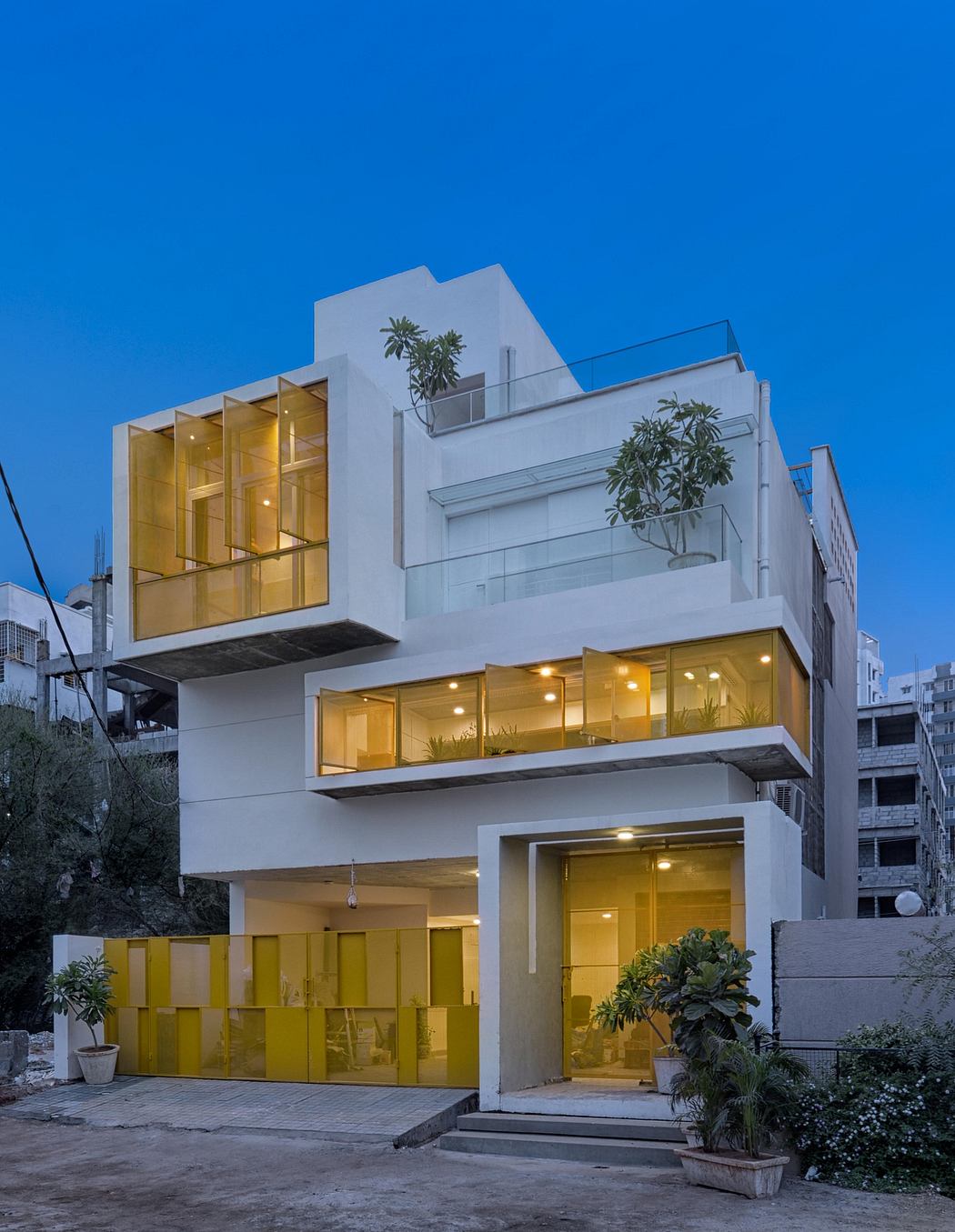 A modern, multi-story building with clean, geometric lines and large, illuminated windows.
