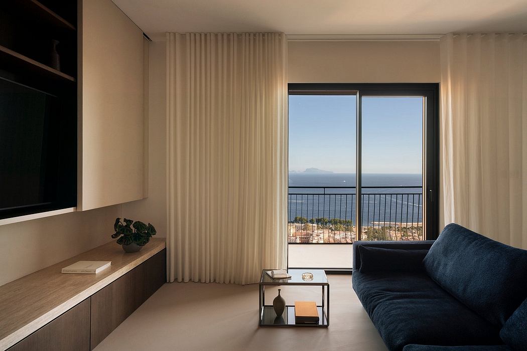 Serene living space with floor-to-ceiling windows offering panoramic sea views and minimalist furnishings.