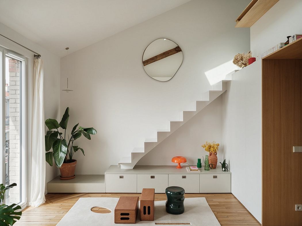 Bright, minimalist interior with curved staircase, built-in storage, and natural materials.