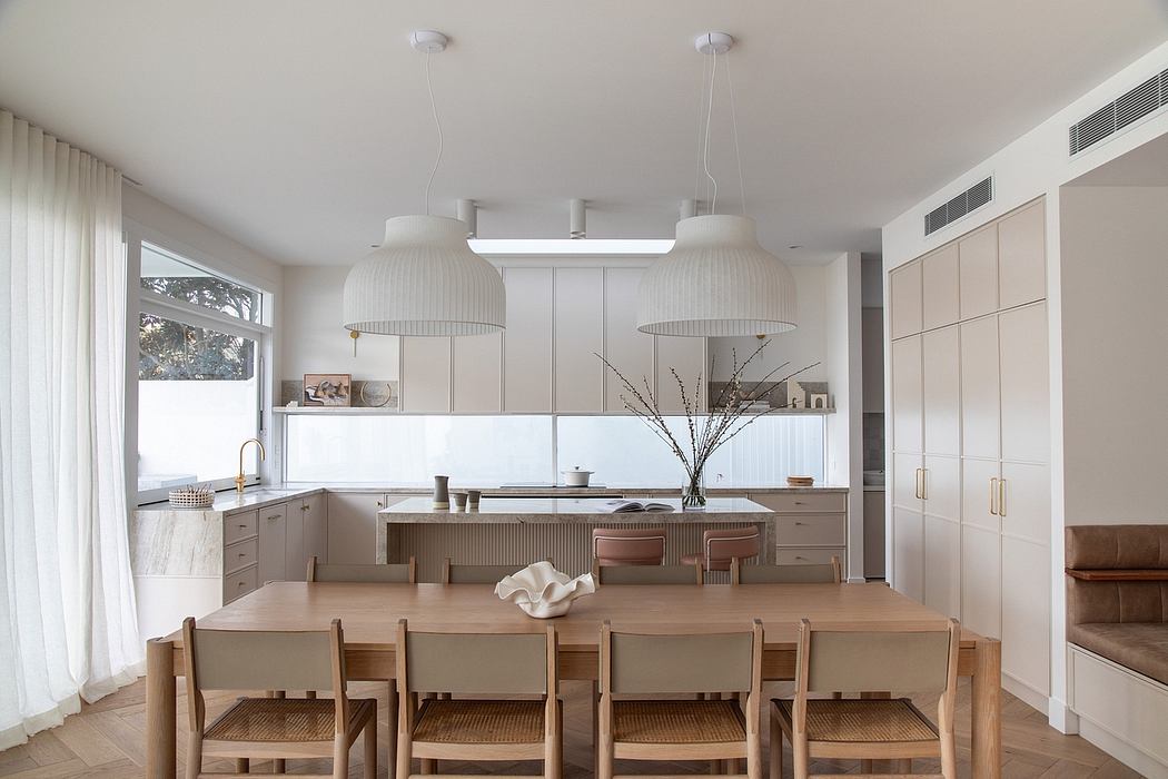 Bright, modern kitchen with large dining table, pendant lamps, and built-in cabinetry.