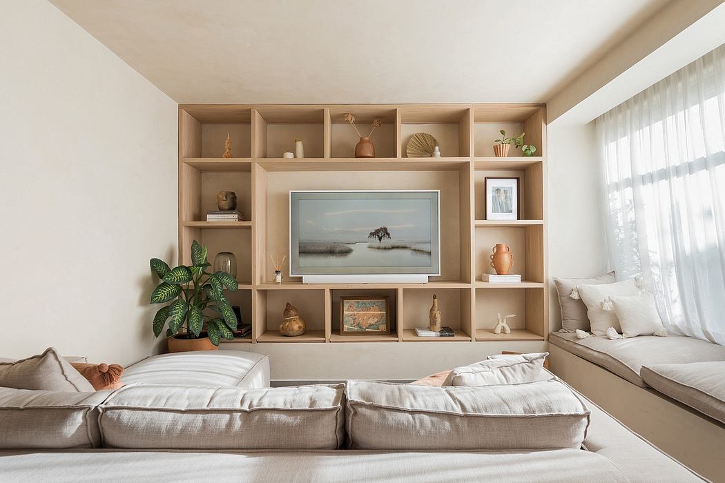 A cozy living room with a built-in wooden shelving unit displaying decorative items.