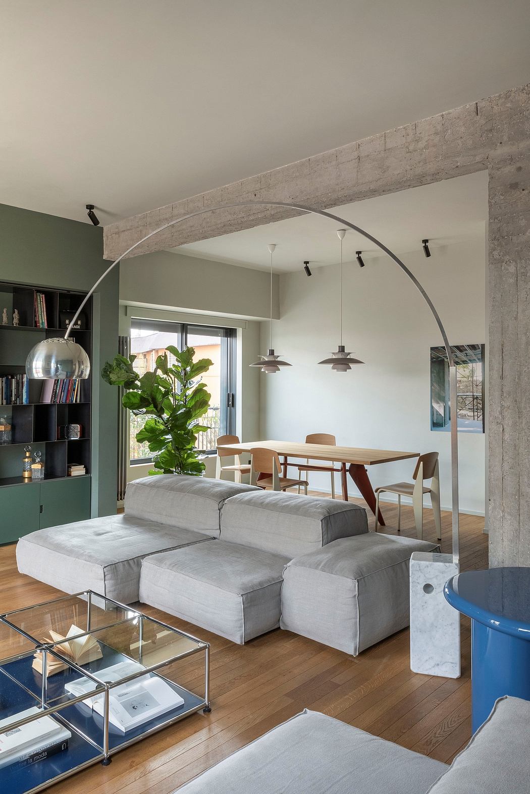 A modern, open-concept living space with concrete arches, wood floors, and minimalist decor.