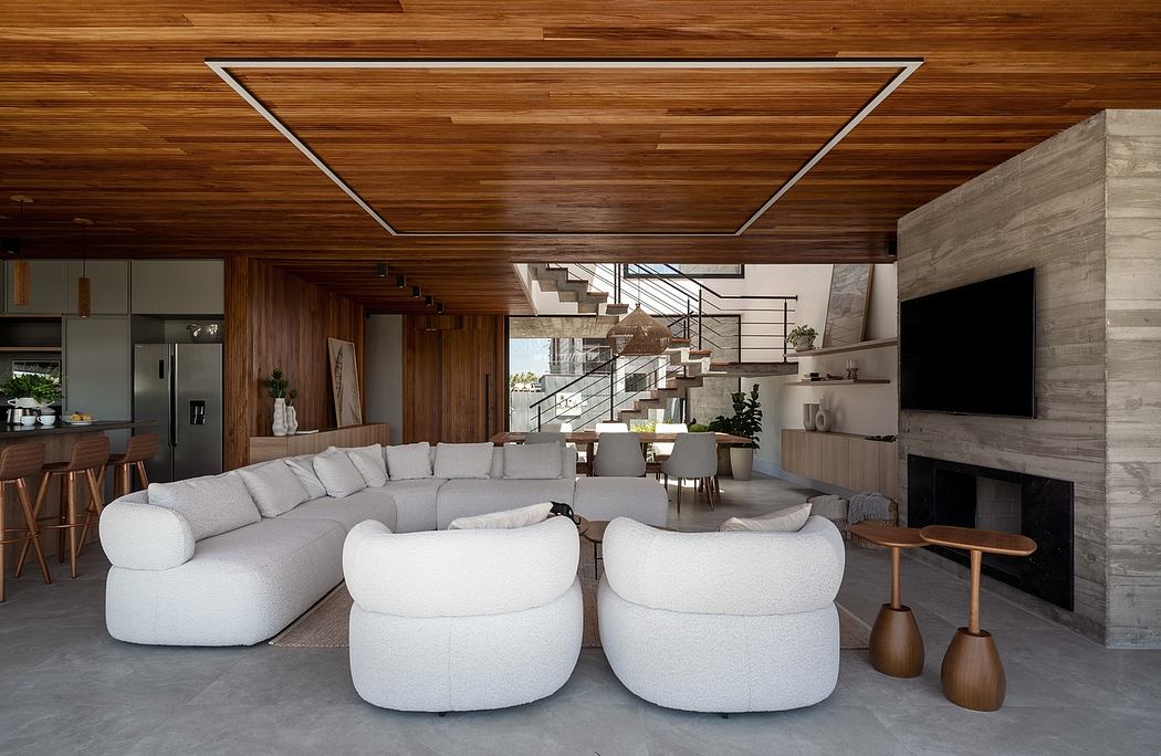 Spacious modern open-plan living area with wooden ceiling, gray couches, and concrete flooring.