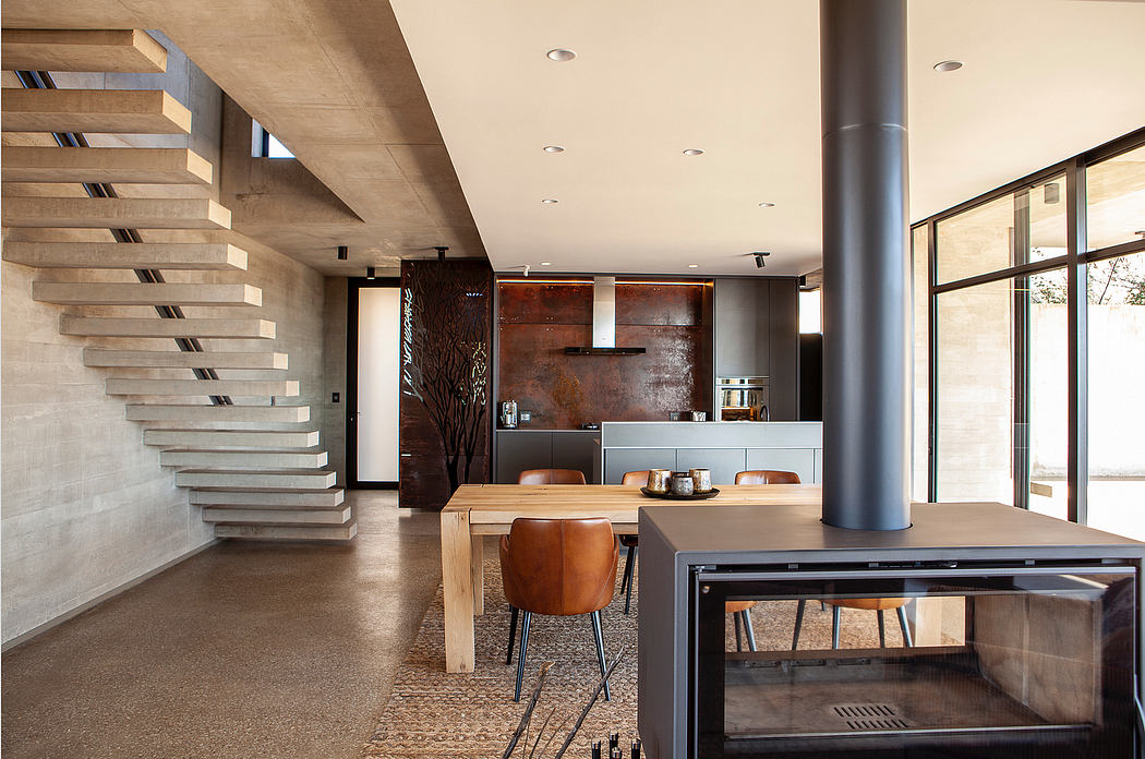 Striking modern open-concept interior with floating concrete stairs, metal accents, and minimalist decor.