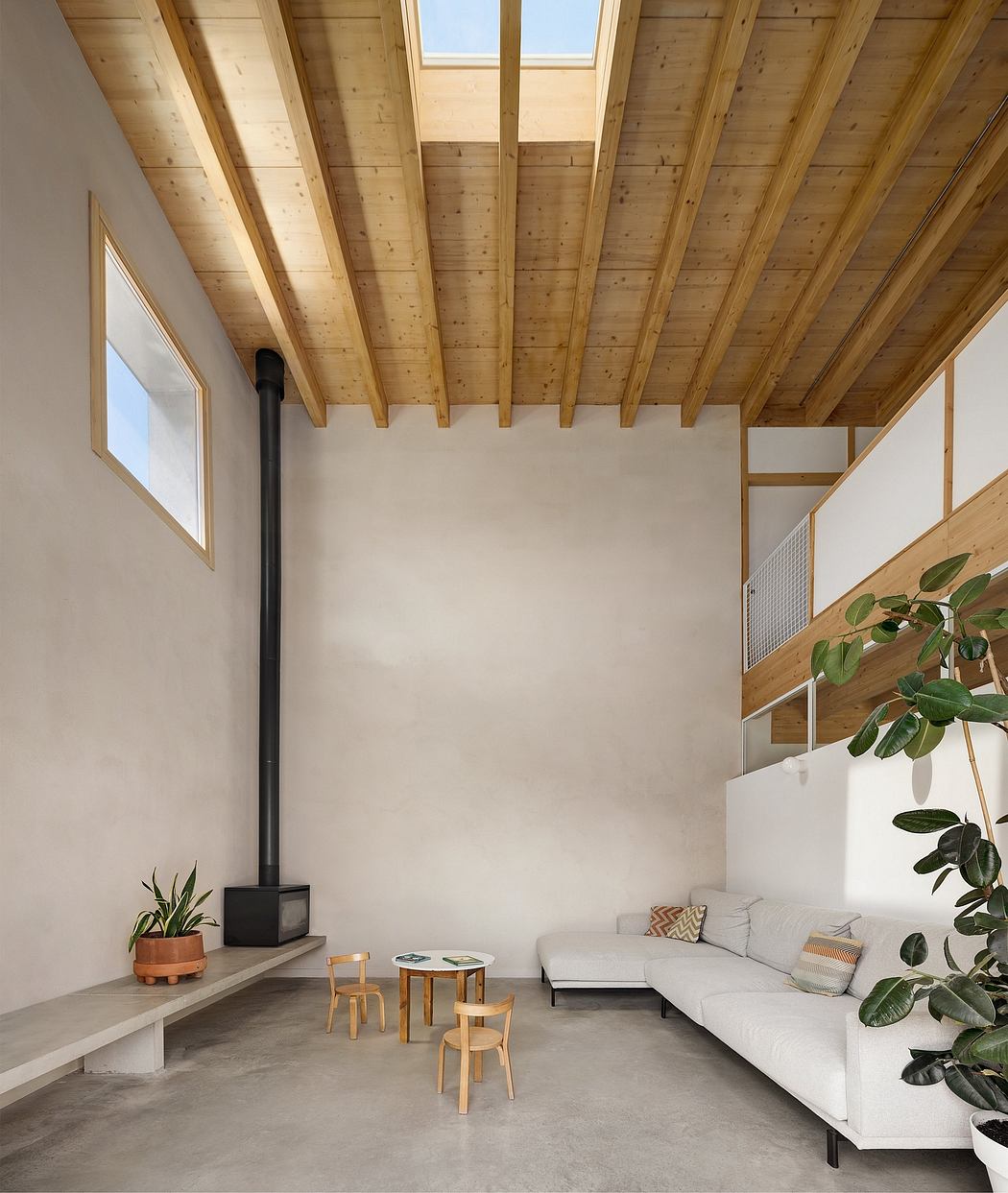 Minimalist living room with wood-beamed ceiling, concrete floor, and potted plants.