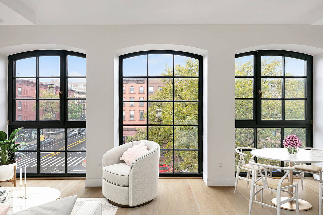 Spacious, modern apartment with large arched windows overlooking city scenery.