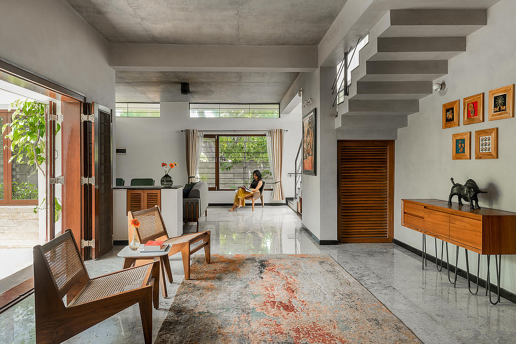 Minimalist living space with concrete walls, wooden furniture, and vibrant artwork.