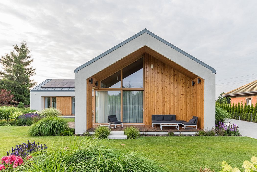 A modern house with a wooden exterior, glass walls, and a covered patio area.