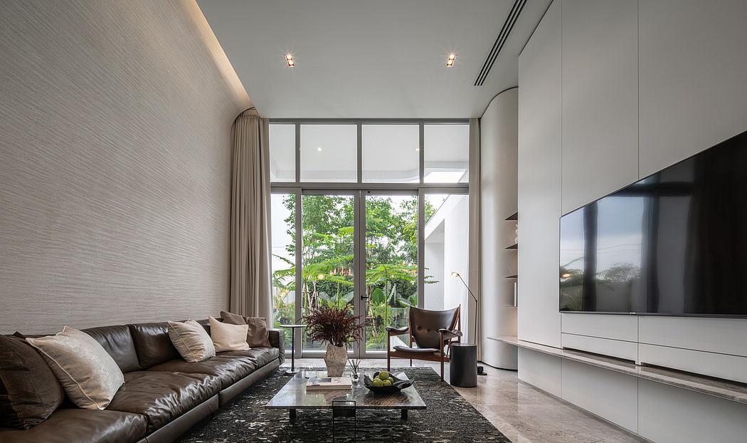 Spacious living room with large windows, minimalist furniture, and modern decor.