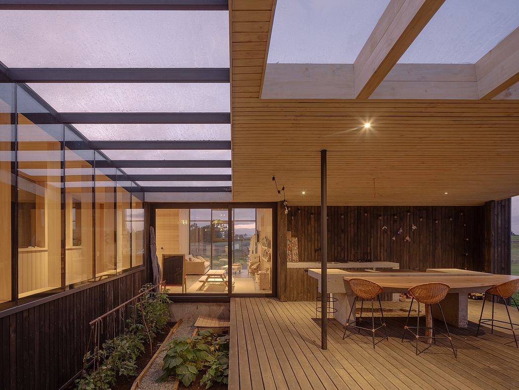 A modern wooden structure with a covered deck, large windows, and a dining area.