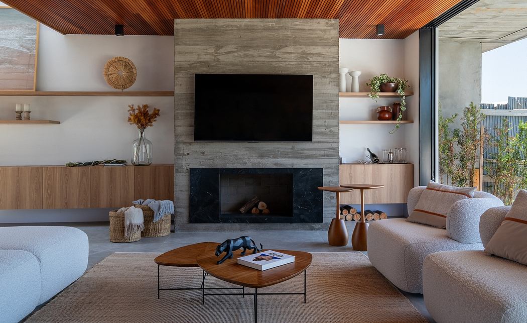 Modern living room with wood-paneled ceiling, concrete fireplace, and built-in shelving.