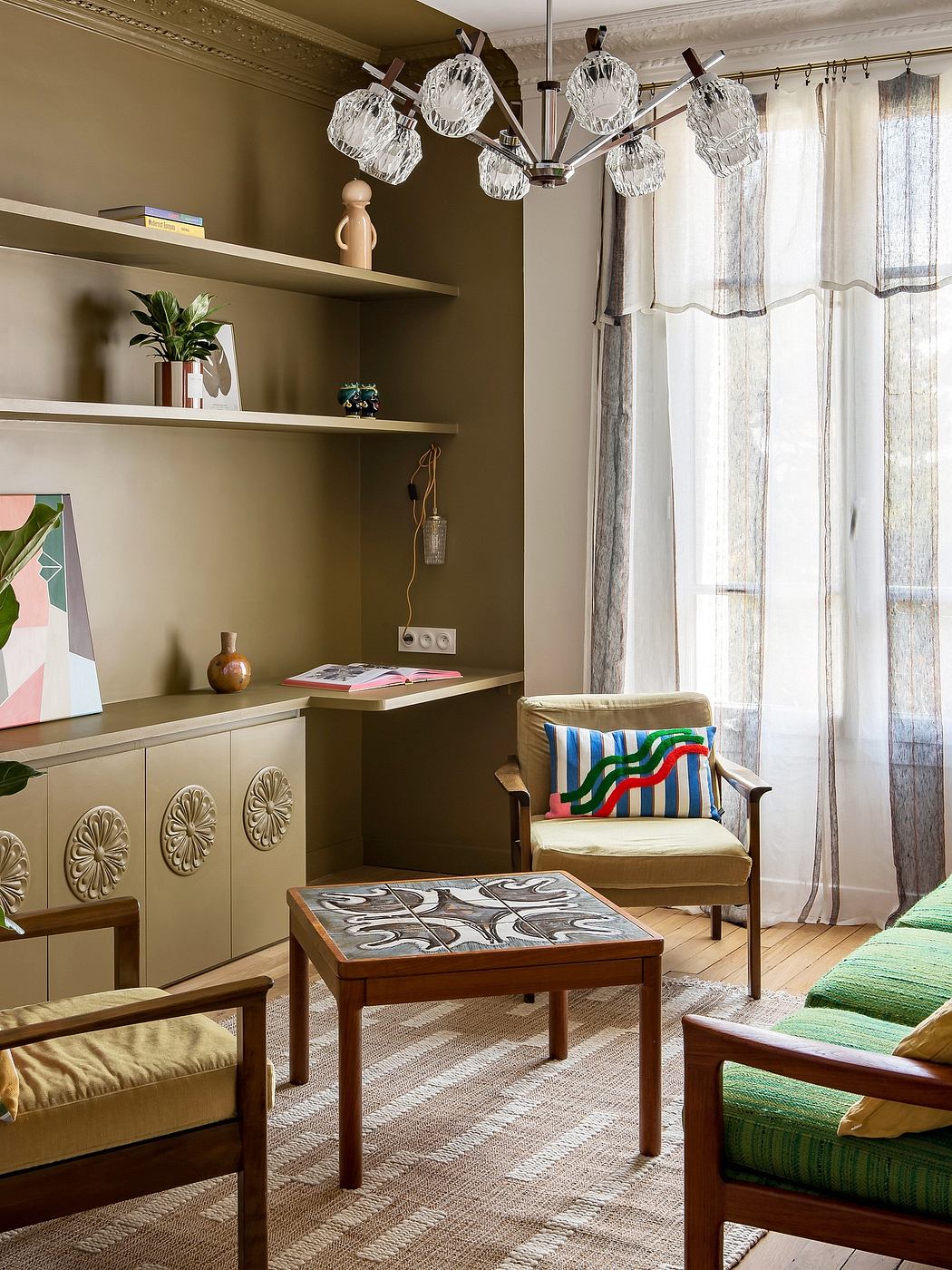 Ornate chandelier with crystal shades, shelves with decorative items, patterned furniture and textiles.