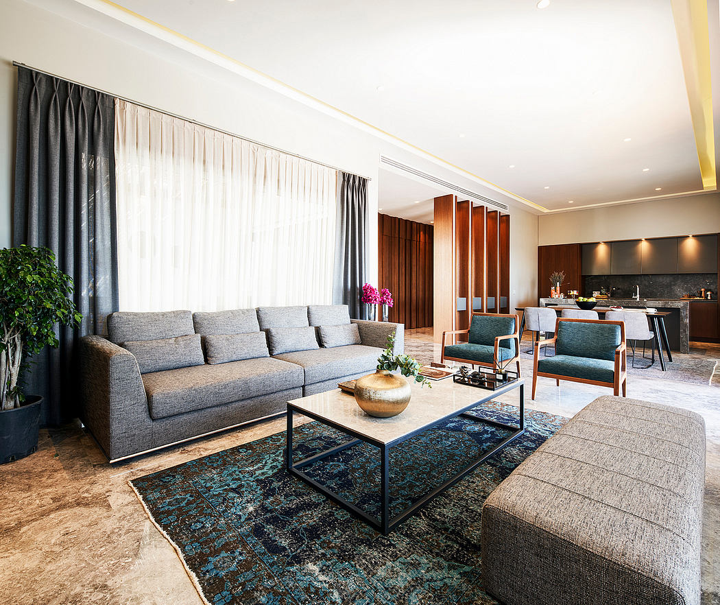 Spacious modern living room with gray sofa, patterned rug, and wooden furniture.