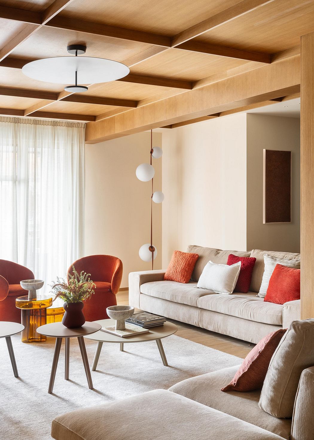 A cozy living room with a modern, wood-paneled ceiling and warm, neutral furnishings.
