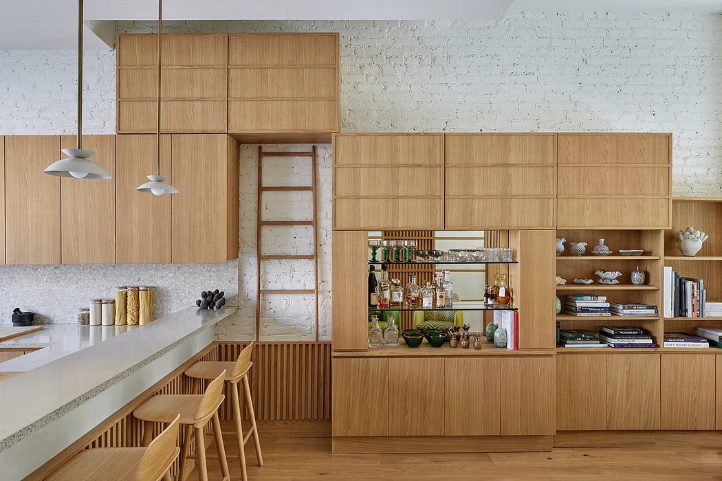 A modern kitchen with wood cabinetry, pendant lights, and a concrete countertop bar.