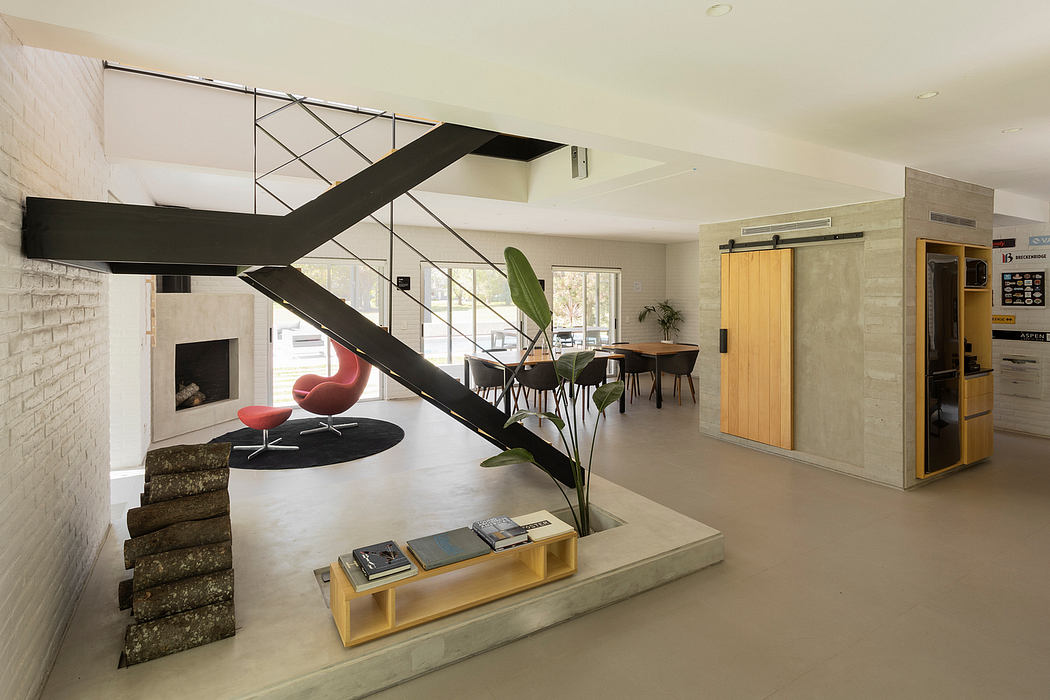 Striking architectural features, including a dramatic metal staircase, modern furniture, and natural elements.