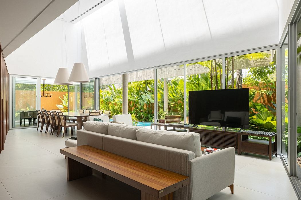 Spacious living area with floor-to-ceiling windows overlooking lush tropical foliage.