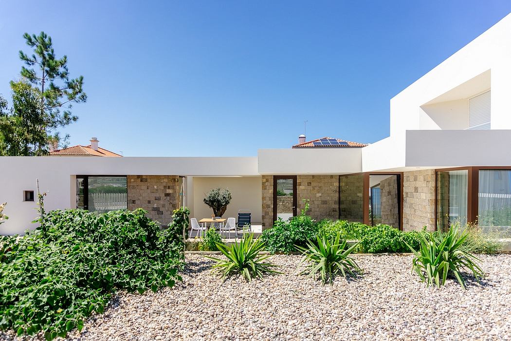 Modern single-story home with lush landscaping, solar panels, and a patio.