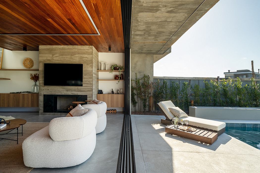 Spacious modern outdoor living area with pool, loungers, and wooden-clad interior.