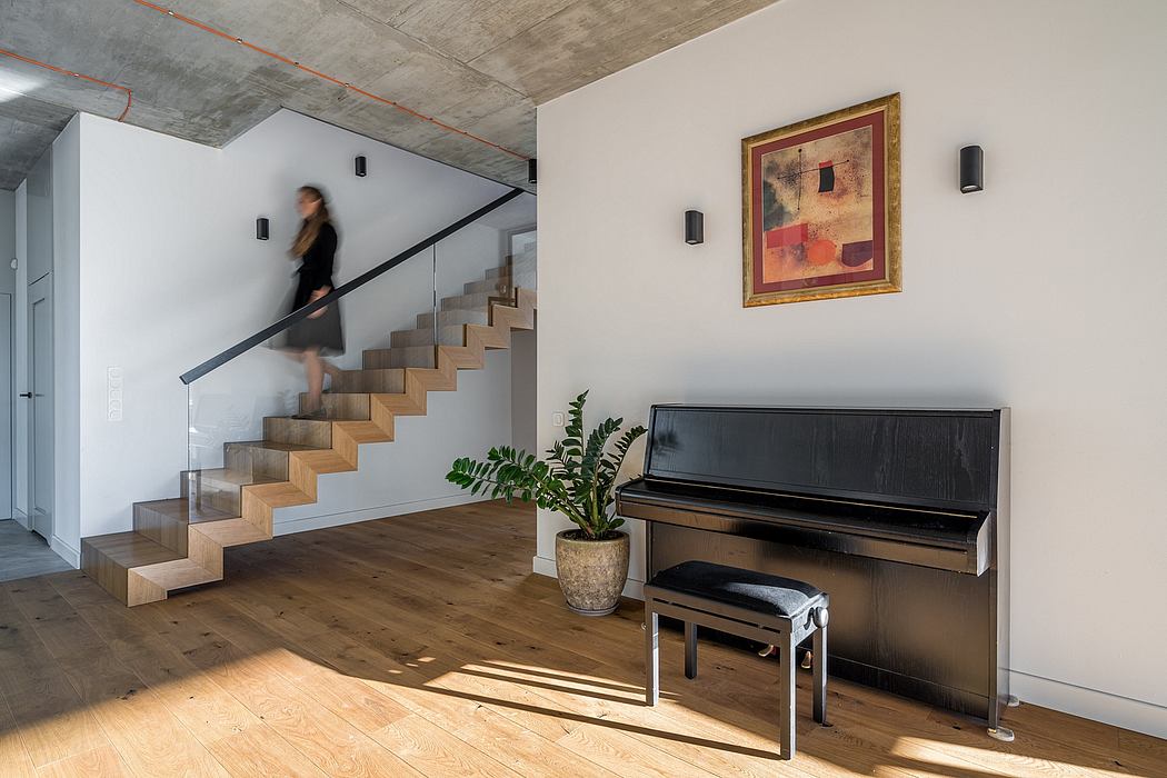 Minimalist interior with concrete ceiling, wooden staircase, and upright piano.