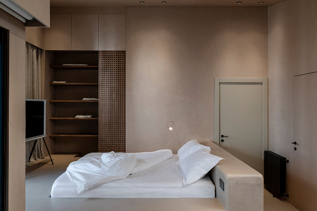 Minimalist bedroom with neutral tones, built-in shelving, and a sleek, modern design.
